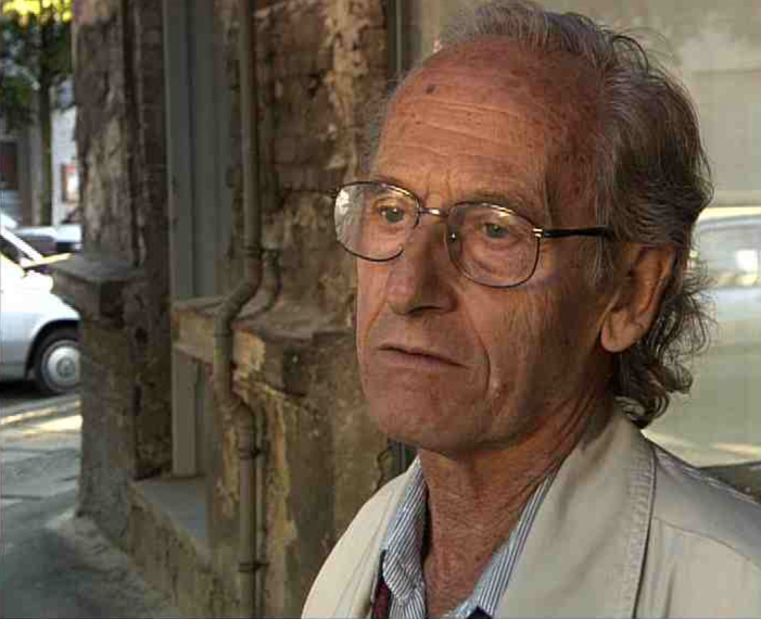 Zvi Aviram steht an der Zehdenicker Straße, er hat den Kopf leicht zur Seite geneigt.